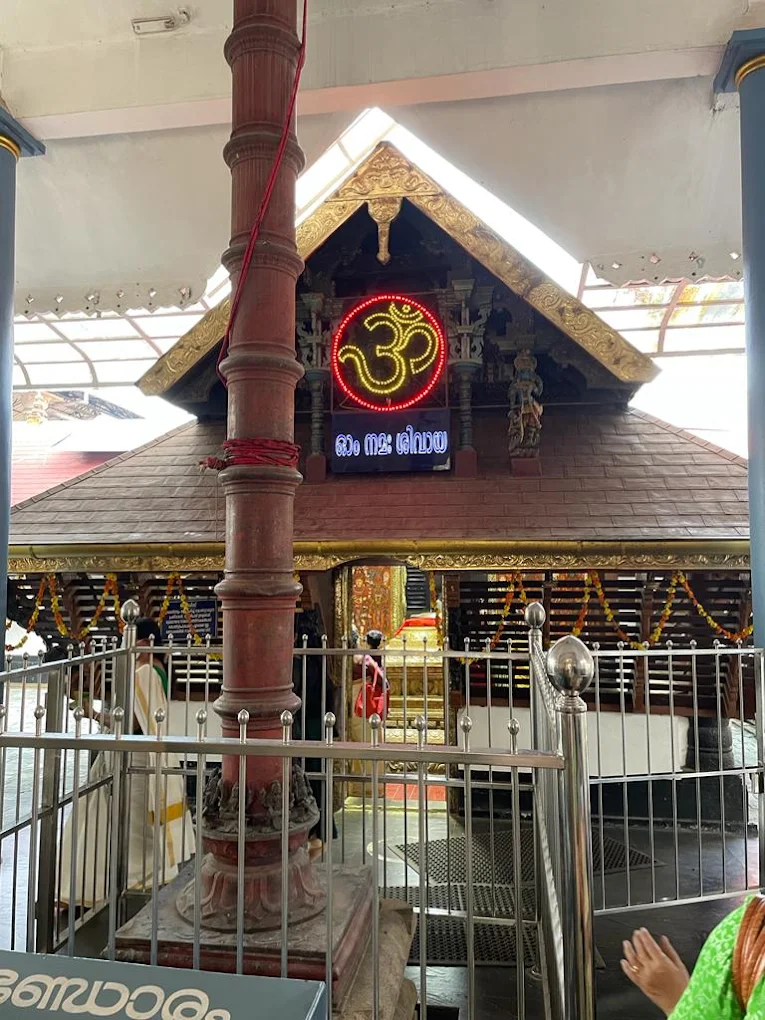 Devotees offering prayers and lighting lamps in the courtyard of Thiruvairanikulam Mahadeva Temple