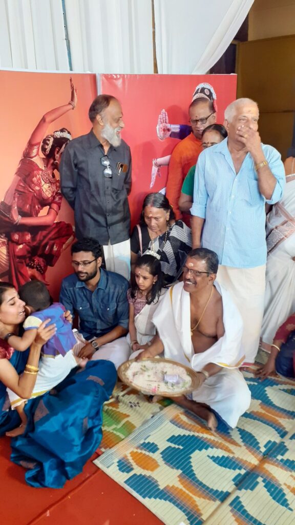 Children performing writing ritual as part of Vidyarambham ceremony